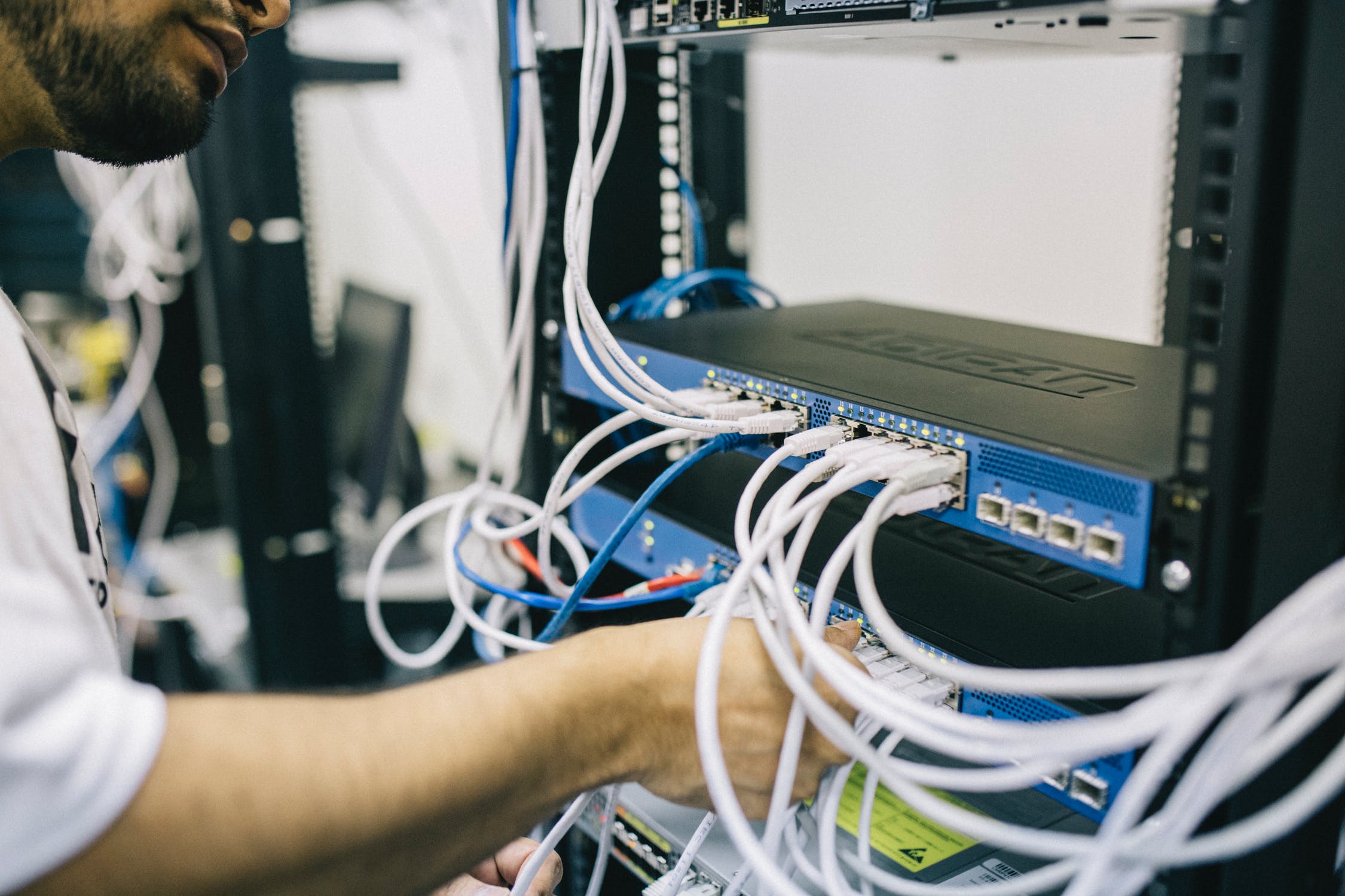 Man plugging in wires to a technology system